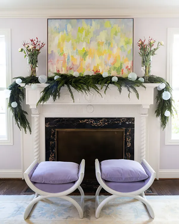 Painting with bright greens above mantle with Christmas greens