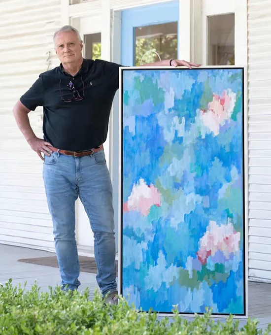 Robert Rea standing with painting